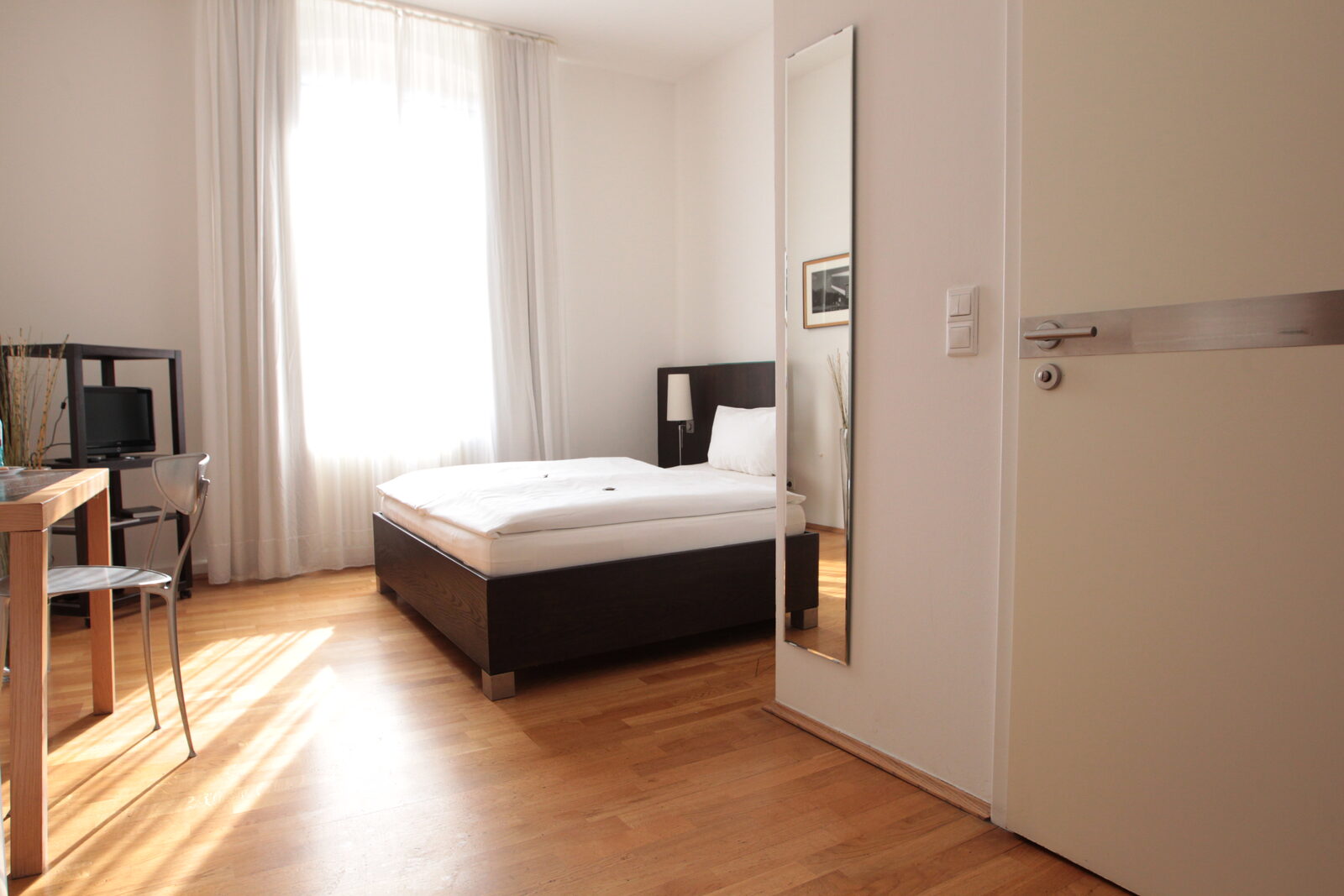 Einzelzimmer mit Schreibtisch und Schrank